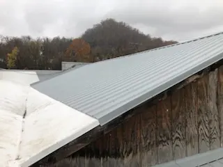 Close-up of a repaired metal roof transition on an awkward roof angle